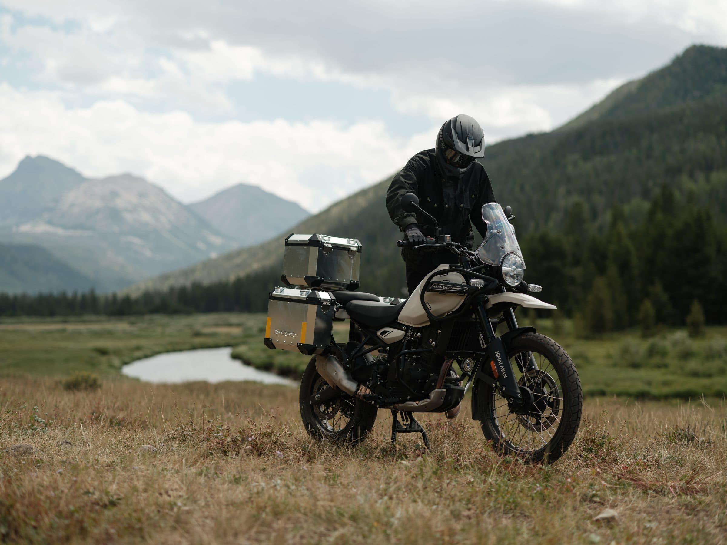 Rider with a rental Royal Enfield Himalayan 450 in a Black Hills meadow